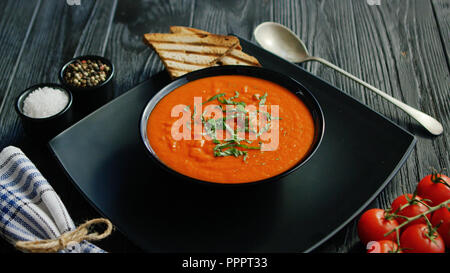 Soupe de tomate dans un bol avec du pain croustillant Banque D'Images