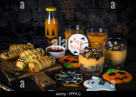 Assortiment alimentaire Halloween - momies sasage, potiron dessert, gin Banque D'Images