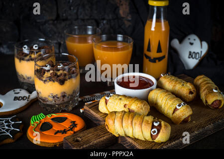 Assortiment alimentaire Halloween - momies sasage, potiron dessert, gin Banque D'Images