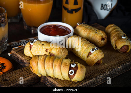 Assortiment alimentaire Halloween - momies sasage, potiron dessert, gin Banque D'Images