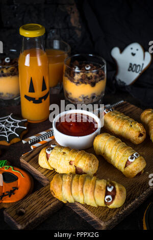 Assortiment alimentaire Halloween - momies sasage, potiron dessert, gin Banque D'Images