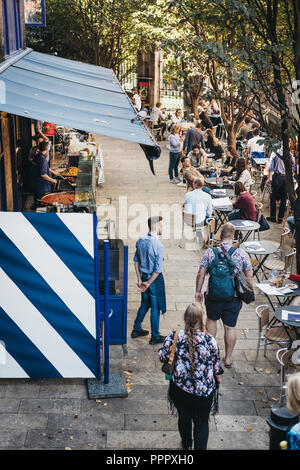 Londres, Royaume-Uni - 17 septembre 2018 : des gens assis à des tables et en passant devant les étals du marché de Borough Market, un des plus grands et les plus anciens marchés de l'alimentation Banque D'Images