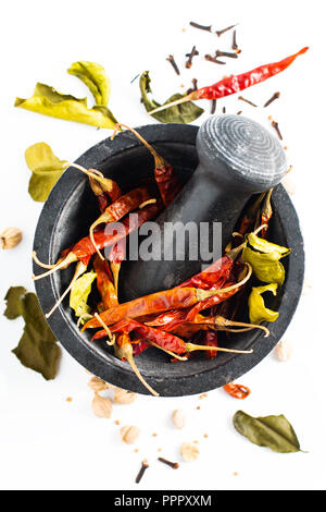 Concept alimentaire thaïlandais exotiques épices séchées piments dans du mortier, Kaffir lime, girofle, cardamome thaïlandais pod blanc et les graines de coriandre sur fond blanc Banque D'Images