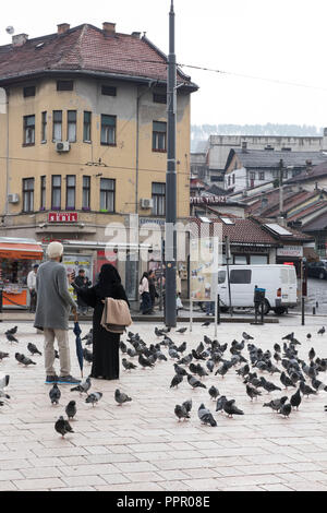 Sarajevo, Bosnie-Herzégovine - avril,2017. Femme musulmane portant burqa en tenant avec selfies pigeons sur Bascarsija square bazar. Banque D'Images