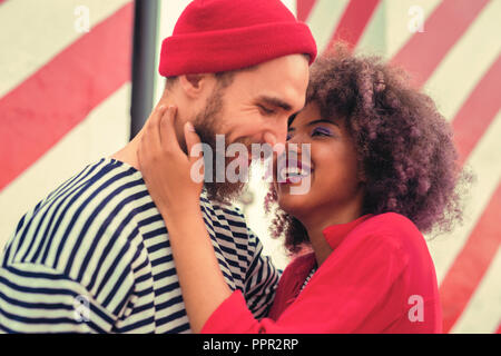 Cute young couple de rire en se tenant debout et s'étreindre Banque D'Images