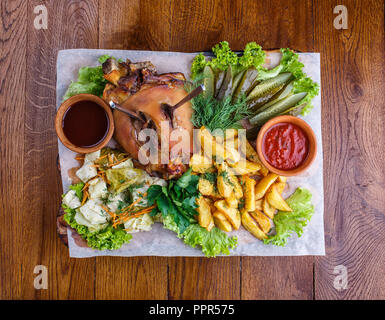 Des en-cas pour la bière au pub. Cuisse de porc fumé avec des pommes de terre, concombres, choux, persil, aneth, salade et sauce rouge. À partir de la photo ci-dessus Banque D'Images