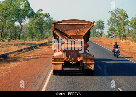 Vue arrière d'un train routier sur la Stuart Highway, UNE MOTO RIDER SE DÉPLACE DANS LA DIRECTION opposée, Territoire du Nord, Australie. Banque D'Images