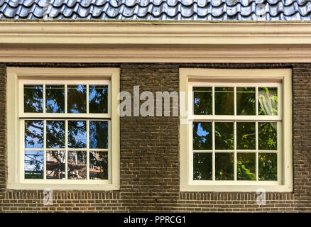 Deux fenêtres à guillotine vintage blanc brun en mur de briques. Bâtiment rétro à Amsterdam, Pays-Bas, éléments architecturaux. Banque D'Images