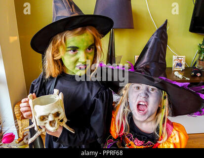 Les petites filles enfants habillés en costume Halloween sorcières, vêtu de noir costume halloween chapeau de sorcière, robes noires. Banque D'Images