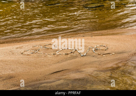 Le mot 'Amour' écrit en pierres sur une plage de sable fin, White Mountain National Forest, NH Banque D'Images