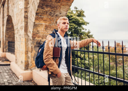 College student avec sac à dos et réservez en admirant la vue paysage de mer à Odessa en marche sur la ville de Rainy day Banque D'Images