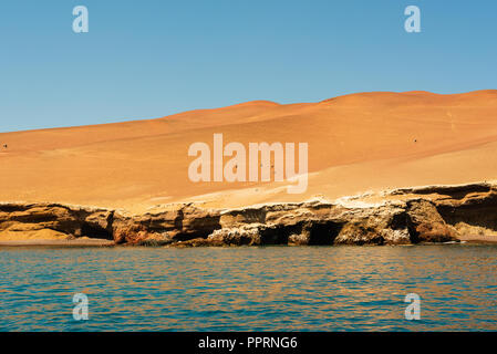 Il y a un ciel bleu sur le désert d'Atacama avec les oiseaux au-dessus de lui alors que le désert et les eaux bleues du Pacifique ci-dessous. Banque D'Images