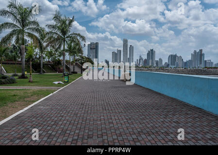 La ville de Panama, Panama -- le 19 avril 2018. Une allée pavée de briques par la plage avec le centre-ville de Panama City dans l'arrière-plan. Banque D'Images