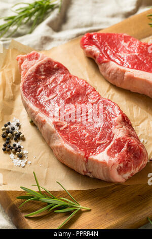 Nourri à l'herbe brute NY Strip Steaks avec sel et poivre Banque D'Images