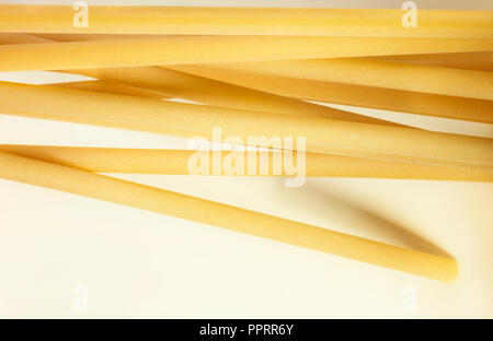 Un groupe de pâtes italiennes appelé ziti sur fond blanc ,long tube vide avec le côté lisse ,composition horizontale Banque D'Images