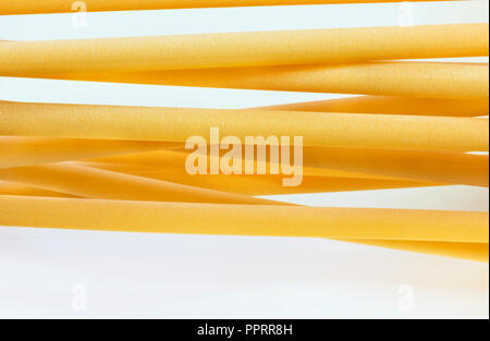 Un groupe de pâtes italiennes appelé ziti sur fond blanc ,long tube vide avec le côté lisse ,composition horizontale Banque D'Images