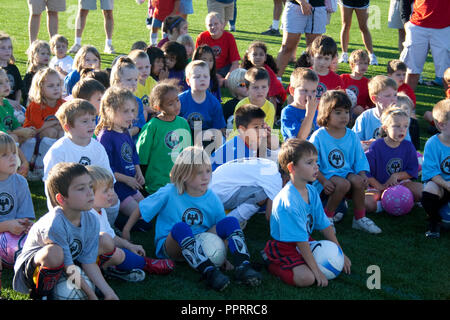 Groupe de garçons et filles de 8 ans prêt à jouer au soccer écoute attentivement à l'entraîneur probablement pas affichées.. St Paul Minnesota MN USA Banque D'Images