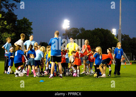 Demandez aux filles âgées de 8 entraîneurs de l'équipe de soccer au cours d'un jeu de nuit. St Paul Minnesota MN USA Banque D'Images