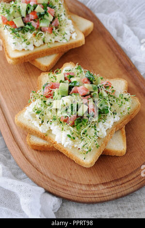 Pour le petit-déjeuner Sandwich tendre, juteuse de germes de luzerne germées avec ricotta, tomate et de tranches d'avocat, avec une tasse de café ou de thé, qui Banque D'Images