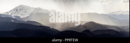 Magnifique vue panoramique sur les montagnes des Carpates brumeuses, couvertes de forêt toujours verte sur calme brumeux matin ou soir sous dark clo Banque D'Images