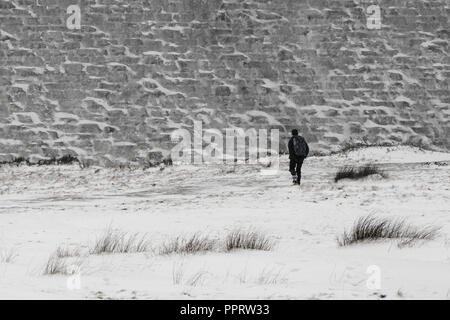 Un homme regarde le Derwent barrage qui est recouverte de glace au cours de la 'bête de l'Est' tempête de mars 2018. Banque D'Images