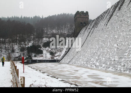 Un homme regarde le Derwent barrage qui est recouverte de glace au cours de la 'bête de l'Est' tempête de mars 2018. Banque D'Images