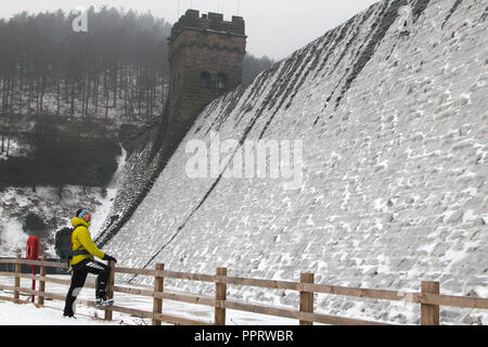 Un homme regarde le Derwent barrage qui est recouverte de glace au cours de la 'bête de l'Est' tempête de mars 2018. Banque D'Images