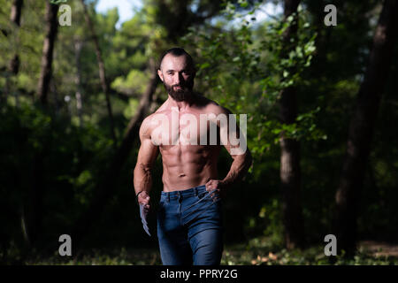 Avec des griffes de superhero Standing Strong Flexing Muscles - Athletic musculaire Fitness Bodybuilder Posing Outdoors Wolverine Banque D'Images