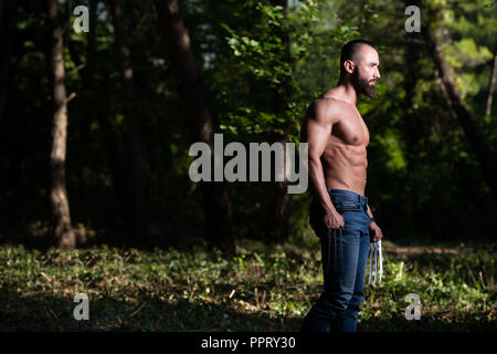 Avec des griffes de superhero Standing Strong Flexing Muscles - Athletic musculaire Fitness Bodybuilder Posing Outdoors Wolverine Banque D'Images