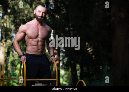 Portrait d'un jeune homme en bonne forme physique montrant son corps bien formé - Remise en forme musculaire Bodybuilder Athletic Model Posing Outdoors - une place pour votre Banque D'Images