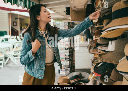 Woman picking hat hat au vendeur, elle est le choix le plus adapté à son chapeau Banque D'Images