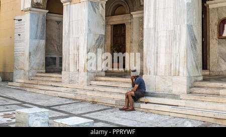 Athènes Grèce/Août 17, 2018 : Woman walking down fermé brocante avec graffiti sur les portes fermées Banque D'Images