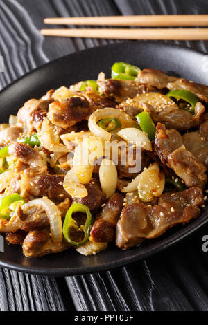 Dak Ddong Jjip - estomacs poulet frit avec des oignons, ail, piment et sésame close-up sur la table. La verticale Banque D'Images