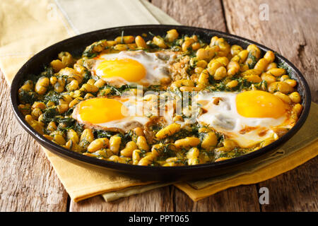 Cuisine iranienne traditionnelle Baghali Ghatogh des haricots et de l'aneth avec les œufs, l'ail et le curcuma close-up dans une poêle sur une table horizontale. Banque D'Images