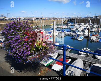 Guernsey, Royaume-Uni : le 25 août 2018 : St Peter Port est la capitale de Guernesey. Les bateaux sont amarrés dans le port de plaisance avec des paniers suspendus sur la barre d'appui Banque D'Images