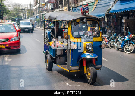 Tuc-tuc, un trois roues-cycle, avec une passagère de la conduite dans les rues de Bangkok, Thaïlande Banque D'Images