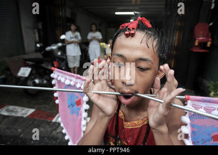 Jeune médium avec de grandes pointes de métal à travers les joues et la bouche de piercing à Phuket, Thaïlande Festival Végétarien Banque D'Images