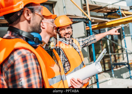 Gros plan de groupe de constructeurs à la voiture équipée at construction site Banque D'Images