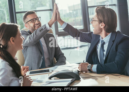 Heureux les gens d'affaires, offrant un rapport cinq au cours de réunion au bureau moderne Banque D'Images