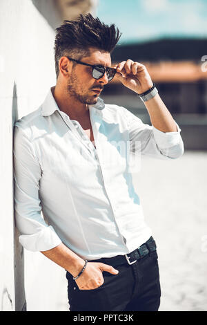 Portrait d'un jeune homme habillé incliné sur mur . Jeune homme à la mode Concept Banque D'Images
