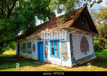 Zalipie, Pologne, le 19 août 2018 : maison colorée avec des fleurs peintes sur les murs et le cadran solaire dans le village de Zalipie, Pologne. Il est connu pour un loca Banque D'Images