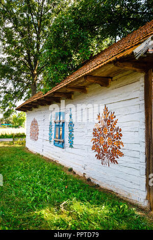 Zalipie, Pologne, le 19 août 2018 : maison colorée avec des fleurs peintes sur les murs et le cadran solaire dans le village de Zalipie, Pologne. Il est connu pour un loca Banque D'Images