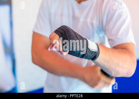 Un homme s'enroule sports bandages sur ses mains. Banque D'Images