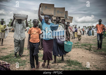 L'Ouganda. 7 mai, 2018. Les femmes réfugiés soudanais du sud vu porter l'huile de palme sur le haut de leurs têtes qu'ils ont reçu ces aliments par le Programme alimentaire mondial. La Bidi Bidi l'établissement des réfugiés dans le nord de l'Ouganda, près de la frontière avec le Soudan du Sud est actuellement le plus grand camp de réfugiés au monde, accueillant plus de 250 000 réfugiés soudanais du sud fuyant le conflit. Le programme alimentaire mondial fournit des approvisionnements alimentaires de base mensuel pour les réfugiés dans le règlement. Credit : Alda Tsang SOPA/Images/ZUMA/Alamy Fil Live News Banque D'Images