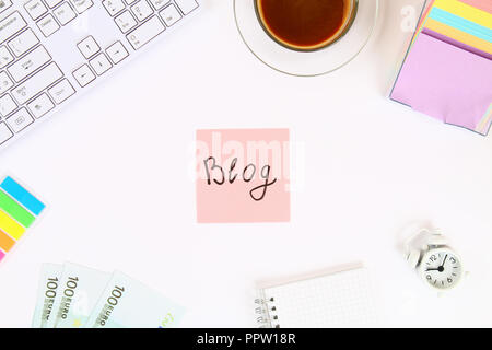 Blog de texte sur un autocollant note sur un bureau blanc à côté d'une tasse à café et d'un clavier. Vue de dessus, la mise en page Banque D'Images