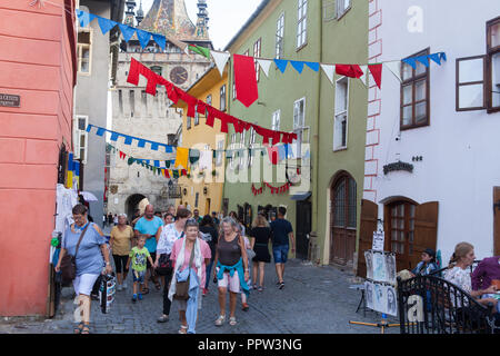 Les touristes à pied à travers les rues de la vieille ville de Sighisoara, Roumanie Banque D'Images