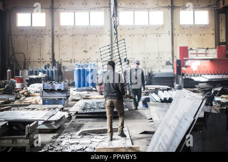 Travailleurs en promenade à l'intérieur de bottes l'usine industrielle Banque D'Images