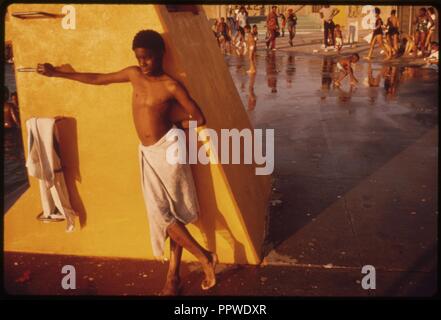 Garçon contre une plate-forme jaune à la piscine dans le Kosciusko Bedford-Stuyvesant ... 07-1974 Banque D'Images