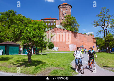 Cracovie, Pologne : Deux jeunes passé cycle Sandomierska Tower (1460) L'une des deux tours d'artillerie du Château Royal de Wawel. Banque D'Images