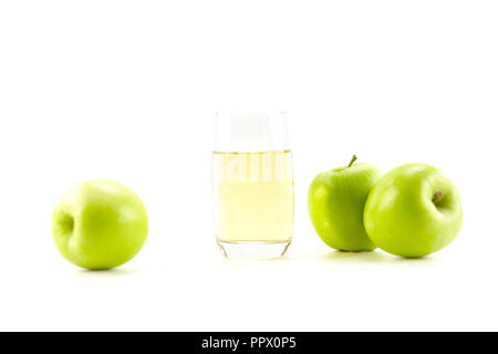 Trois pommes vertes et un verre de jus de pomme isolé sur fond blanc. Banque D'Images